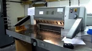Guillotine paper cutter cutting a paper stack