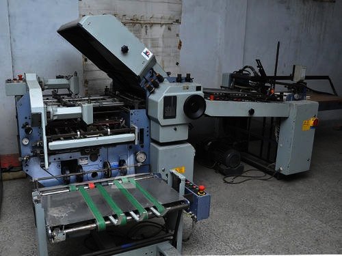 Folding machine with pile feeder in a workshop