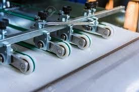 Close-up of folding machine rollers and slitter wheels