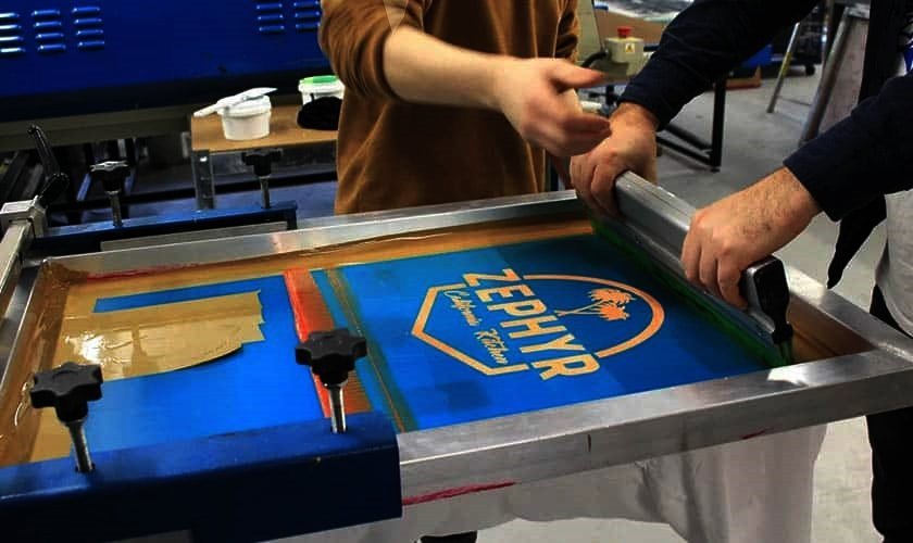 Printing a logo by hand on a screen printing press